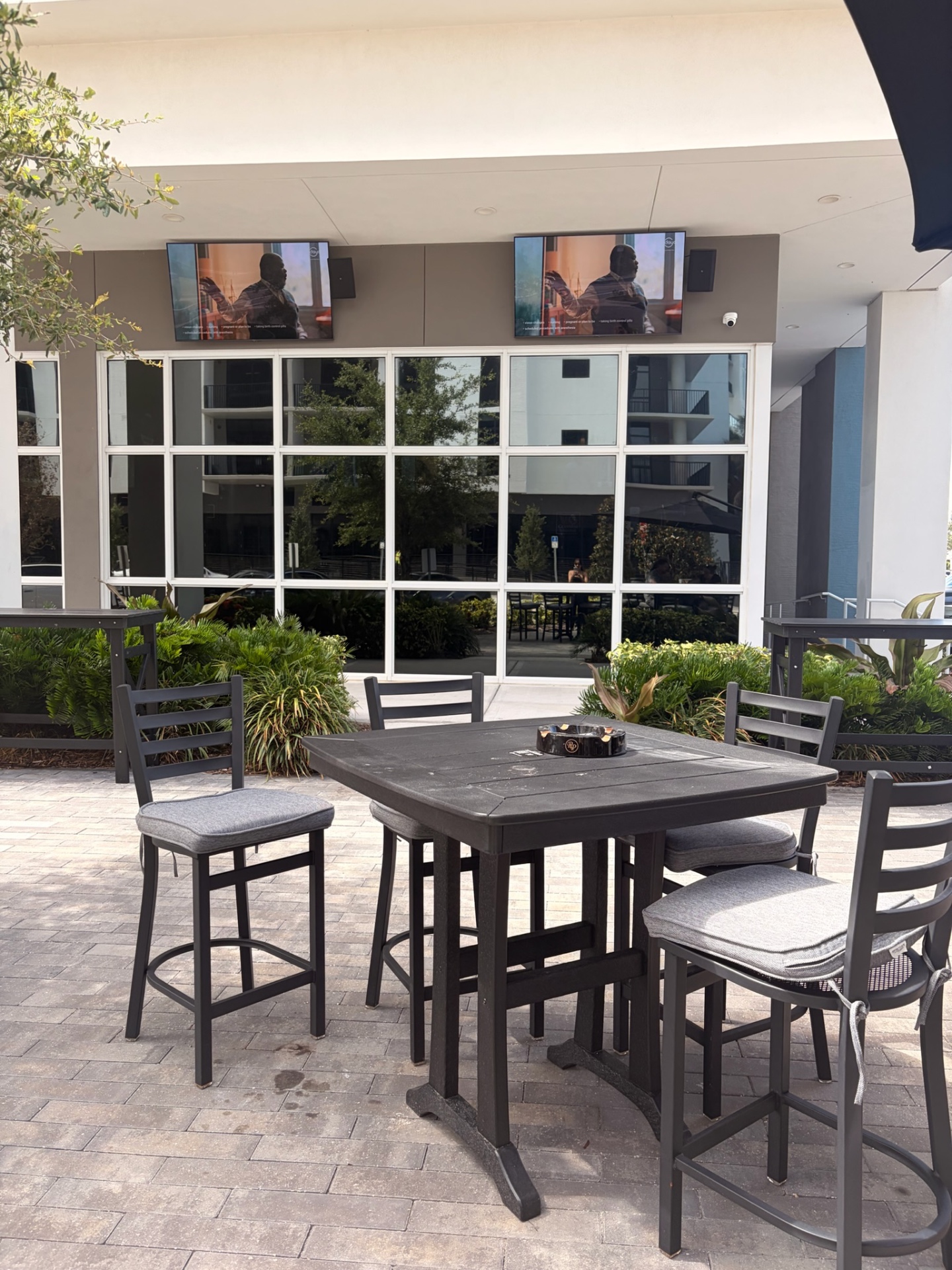 Outdoor patio seating with TVs mounted above the windows