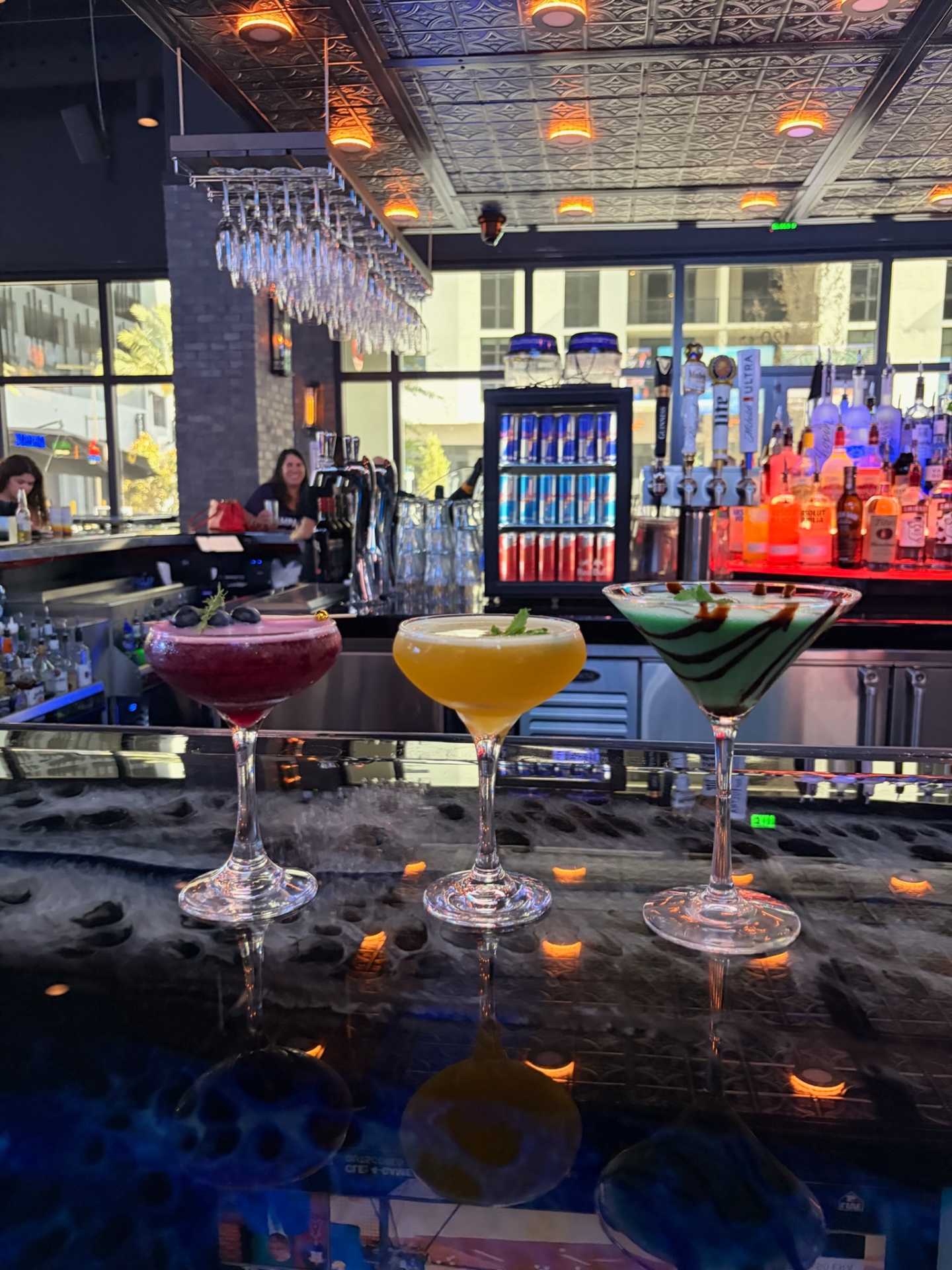 Three martini-glass cocktails lined up at the main bar