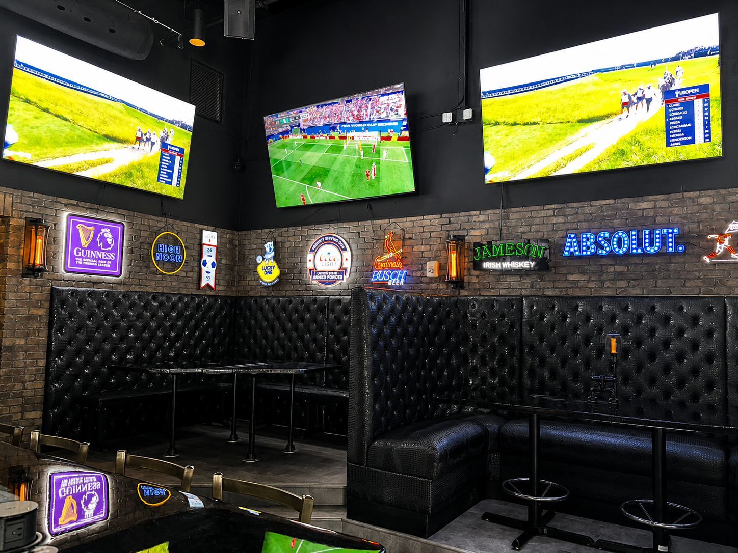 Birthday celebration setup at Back Bar with booth seating, neon signs, and TVs showing the game