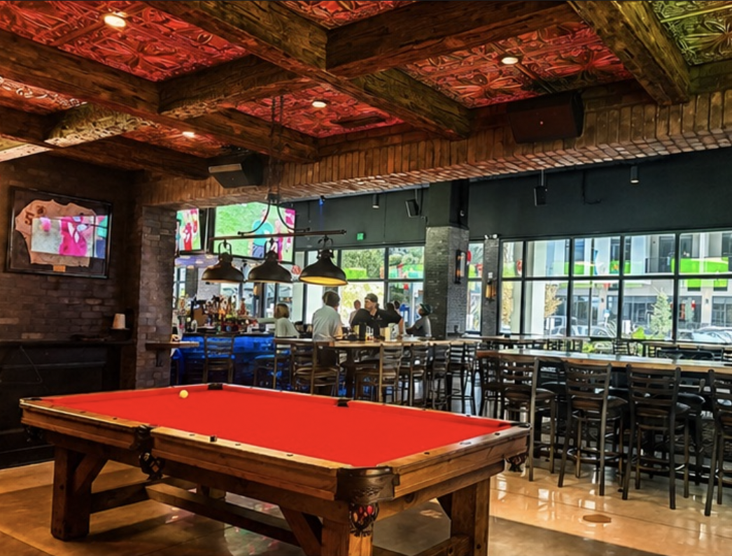 Red-felt pool table with bar seating on the entire lounge side at Back Bar